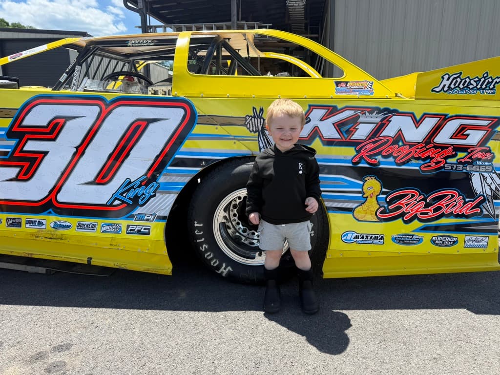 Kamden standing in front of the #30 at the shop