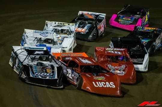 A pack of Super Late Models bunched up heading into the corner