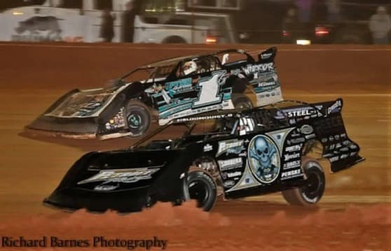 Warrior House Car #1G racing door to door with Scott Bloomquist's #0 under the lights