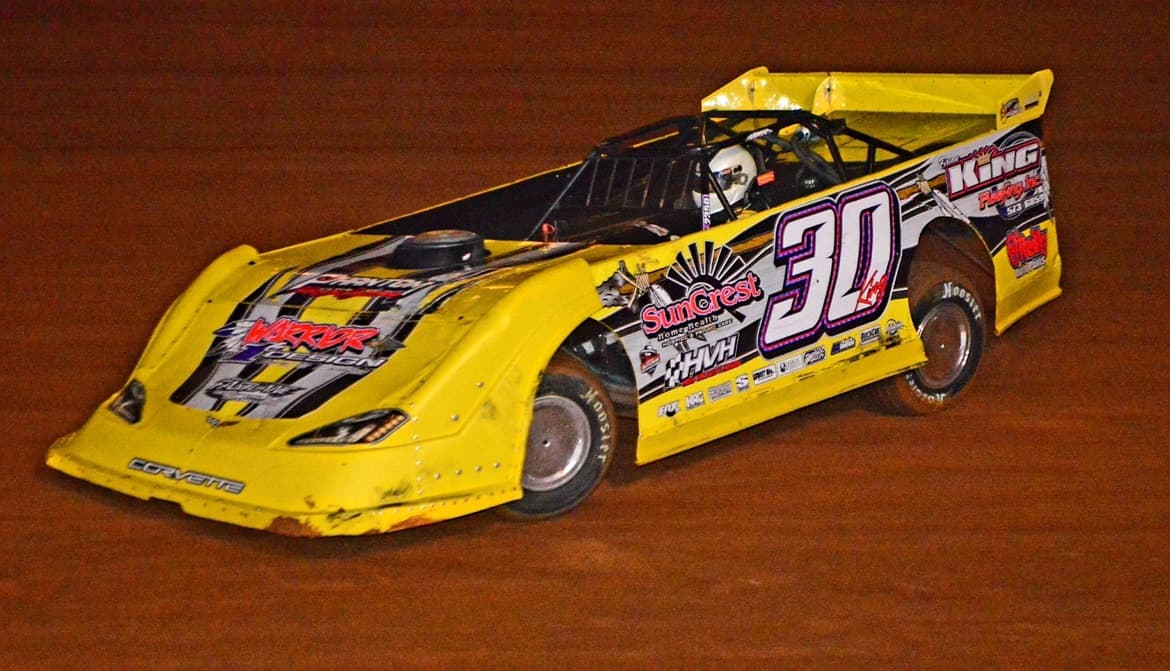 Yellow #30 with Warrior Design and SunCrest Home Health livery sliding through the corner